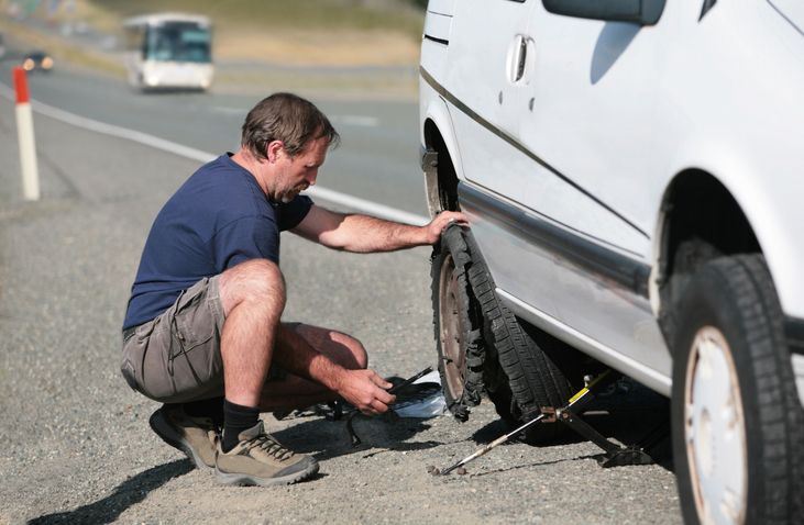 man on the side of the road fixing car