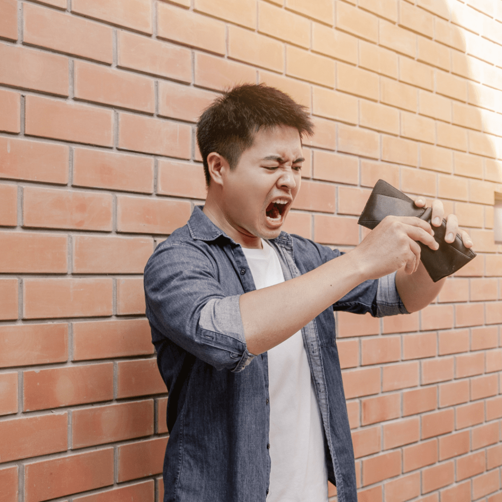 image of an angry mad holding an empty wallet upside down indicating he had to pay more than expected for ride share hidden fees