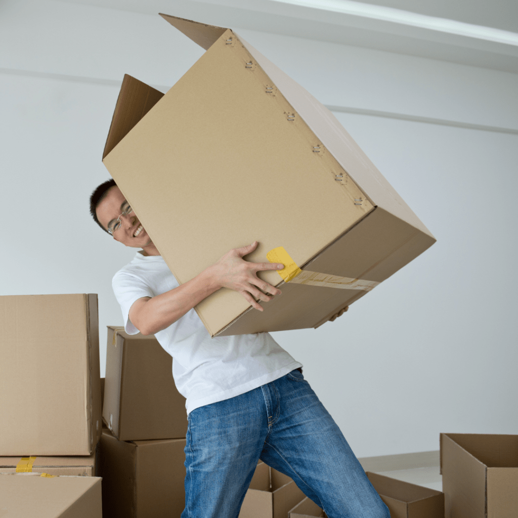 a man smiling and carrying moving boxes