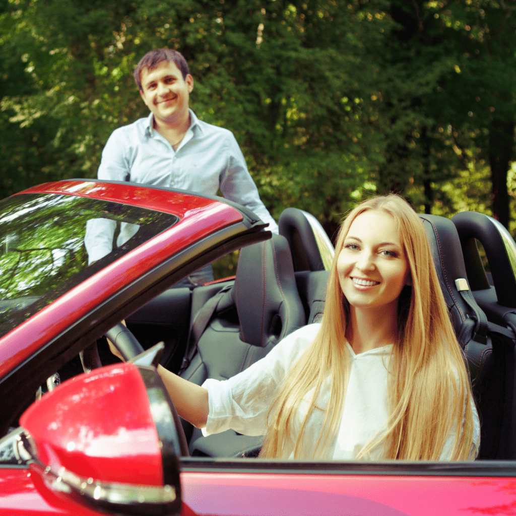 two people in a sportscar representing the concept of someone renting a car for someone else