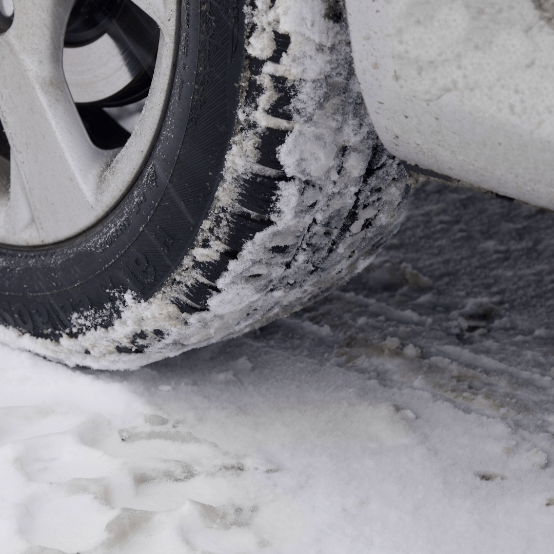 a car tire covered in snow representing safe winter driving