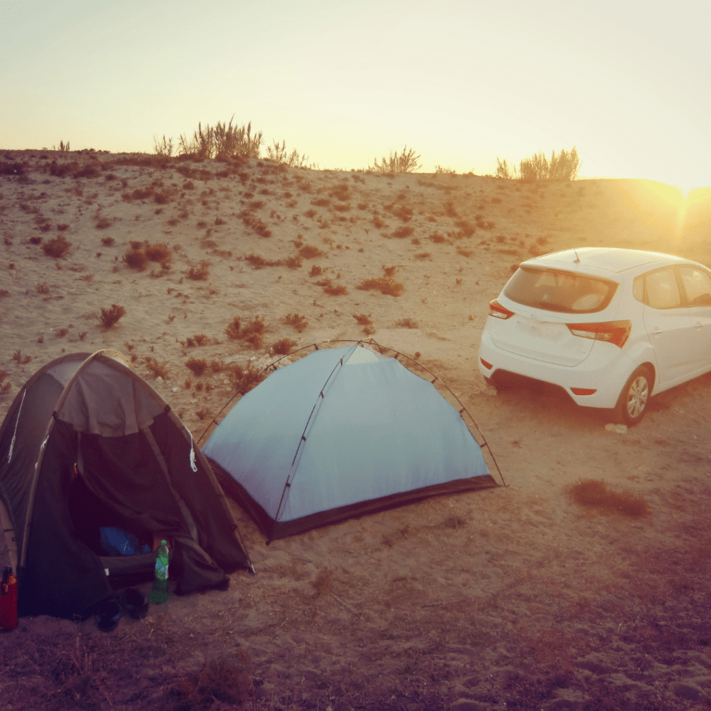 tents and a car in the desert representing unique road trip destinations