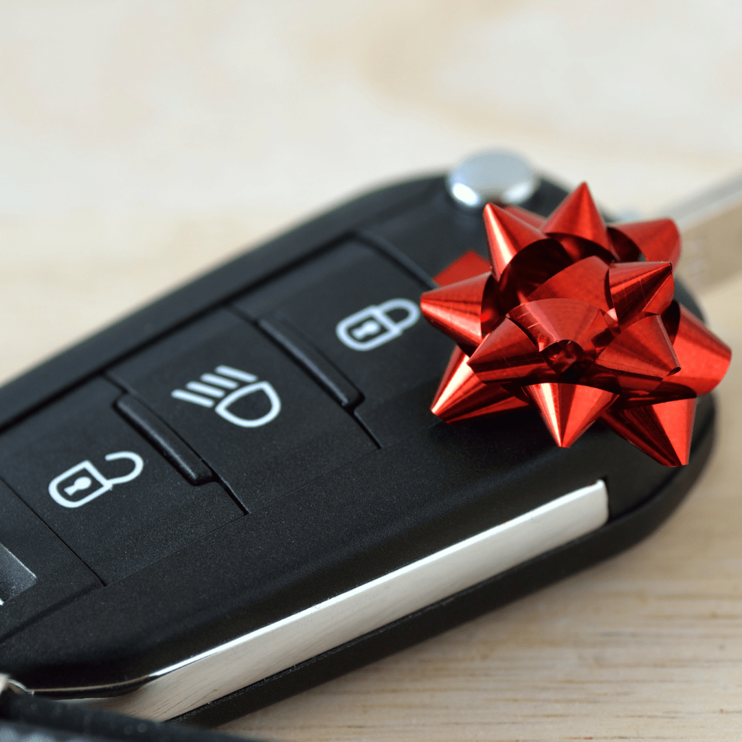 car keys with a gift bow representing someone renting a car for someone else