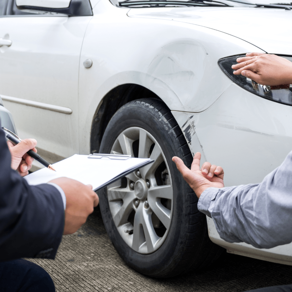 two people inspecting damage to a car before a rental car return